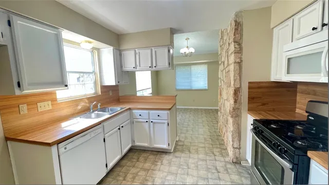 a kitchen with a sink stove and cabinets