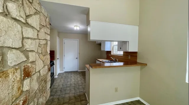a view of a kitchen with a sink and cabinets