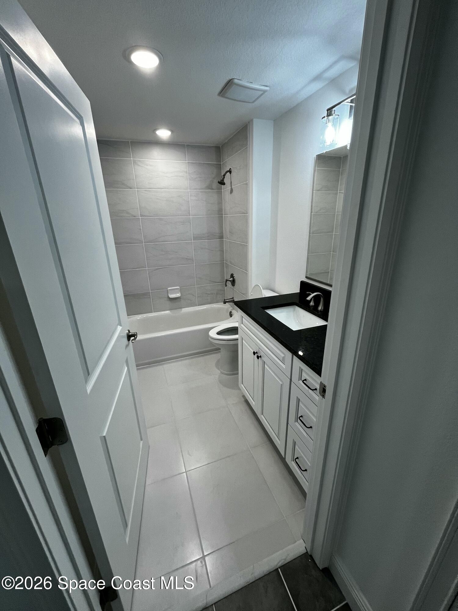 735 Pilot Lane, Unit 612 Merritt Island, FL 32952 - Photo 5 of 18 a bathroom with a sink a toilet a mirror and shower