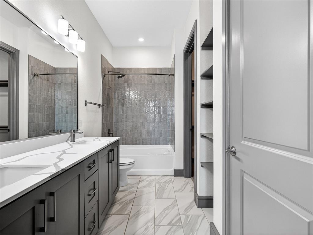 2700 Old Denton Road, Unit 3370 Carrollton, TX 75007 - Photo 18 of 35 a bathroom with a granite countertop sink a toilet a mirror and shower