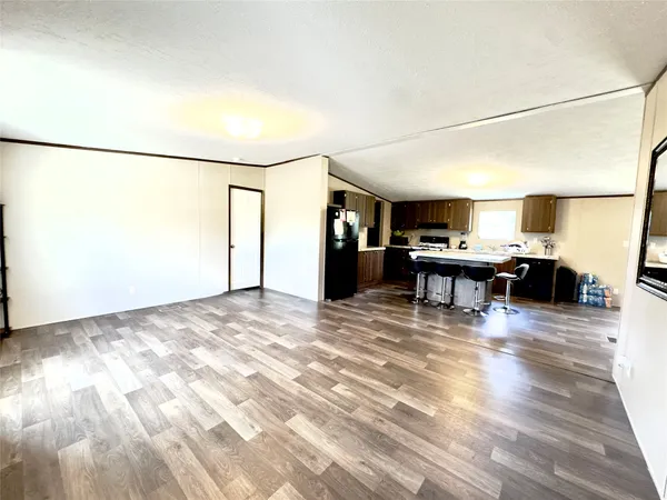 a view of a livingroom with furniture and a kitchen view