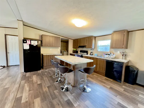 a kitchen with a sink appliances a counter space and a window