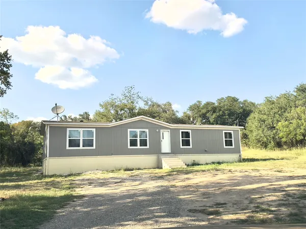 a view of a house with backyard and trees