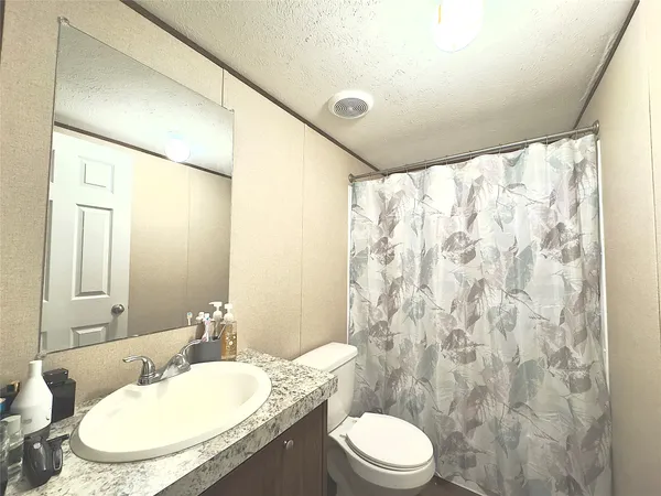 a bathroom with a granite countertop sink toilet and shower