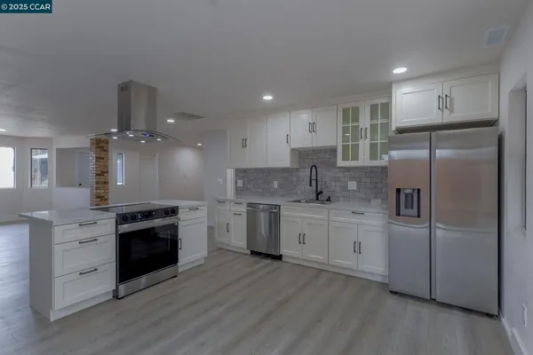 a kitchen with kitchen island granite countertop a stove and a sink