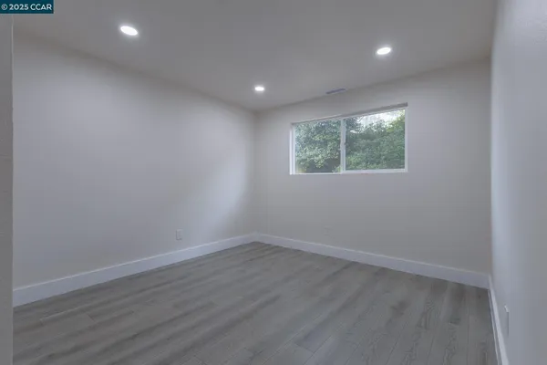 a view of an empty room with wooden floor