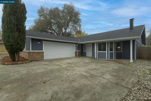 a view of an empty room with wooden floor and a fireplace