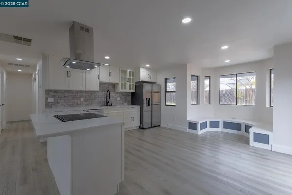 a view of a kitchen with kitchen island a sink wooden floor and counter top space