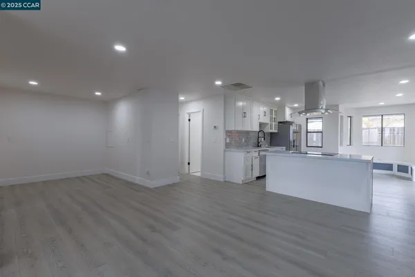 a kitchen with granite countertop a refrigerator stove top oven and sink