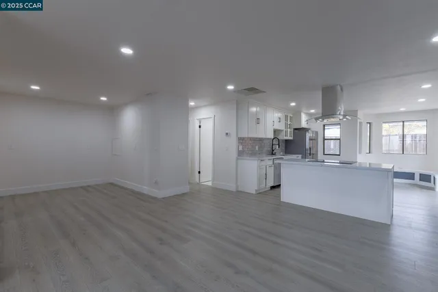a kitchen with granite countertop a refrigerator stove top oven and sink