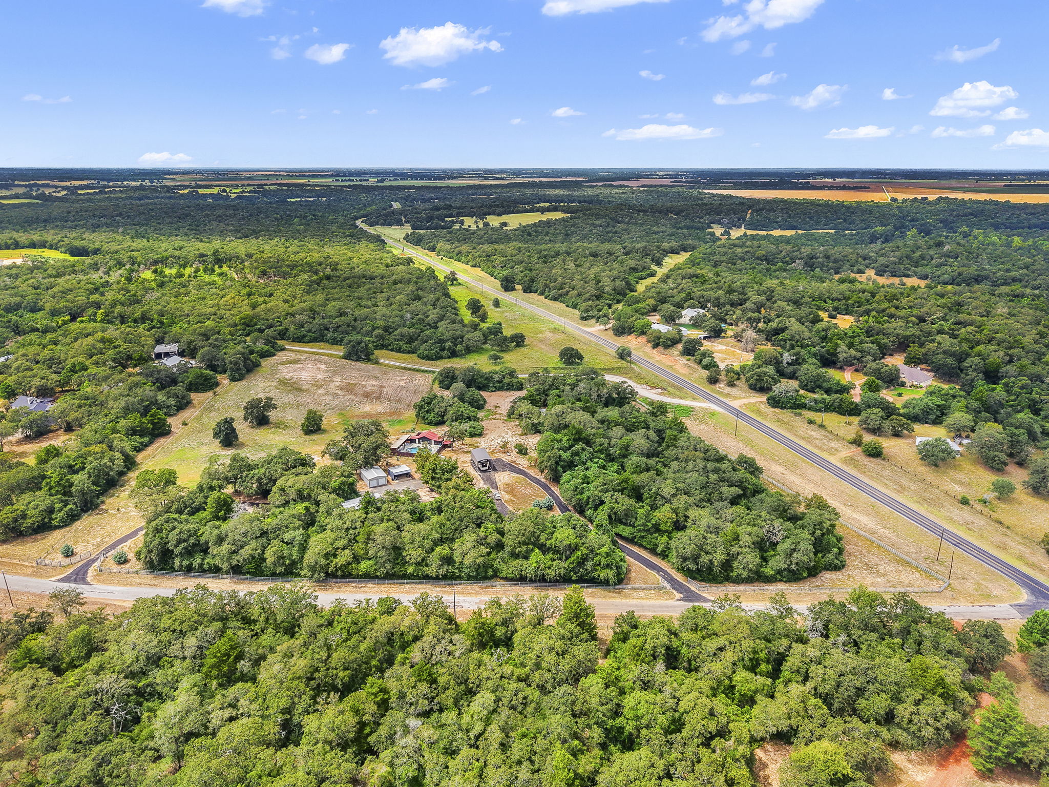 206 22 Hills Road Gause, TX 77857 - Photo 26 of 28 Lush woodlands envelope the sprawling acreage under expansive blue skies.