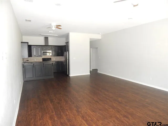 a open kitchen with cabinets wooden floor and stainless steel appliances
