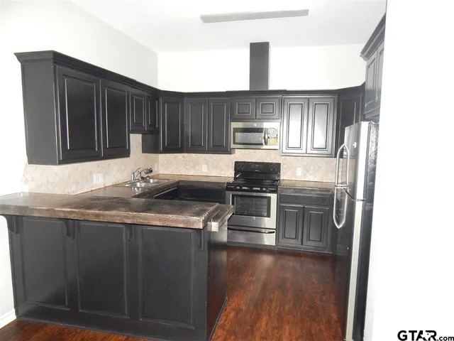 a kitchen with stainless steel appliances a sink stove and refrigerator