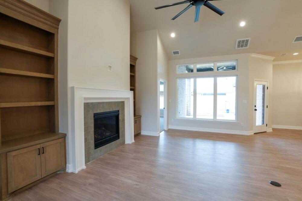 7516 56th Street Lubbock, TX 79407 - Photo 12 of 31 a view of an empty room with a fireplace and a window