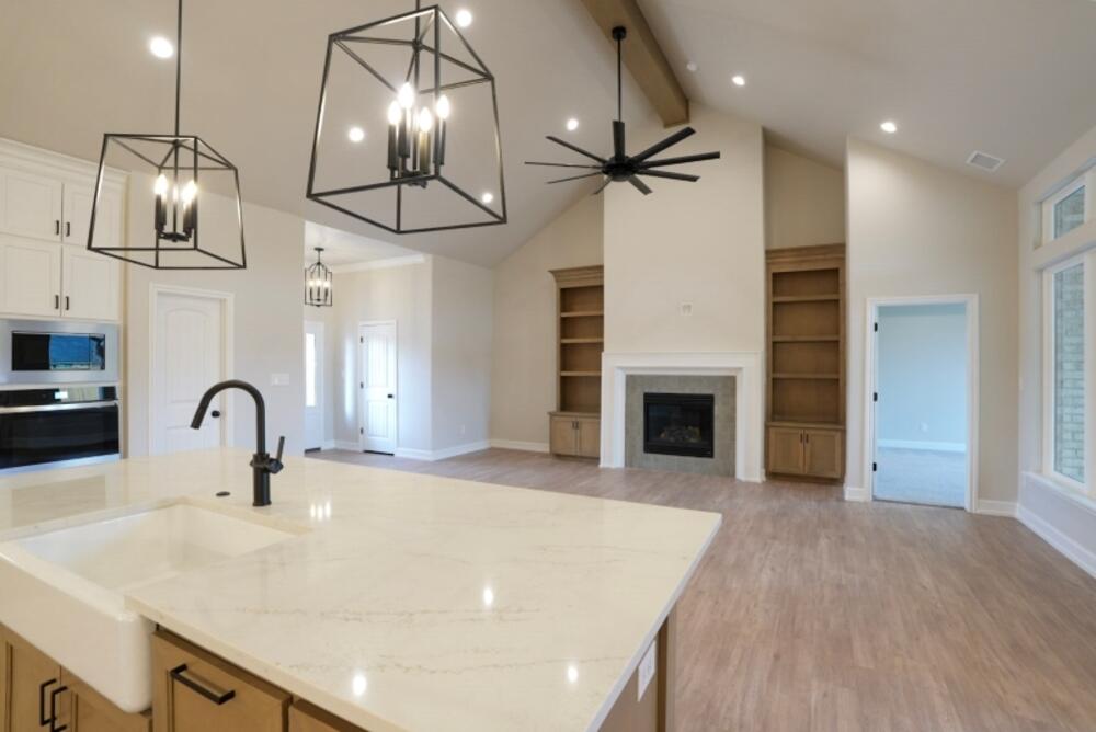 7516 56th Street Lubbock, TX 79407 - Photo 15 of 31 a kitchen with stainless steel appliances a kitchen island a stove and a sink with wooden floor