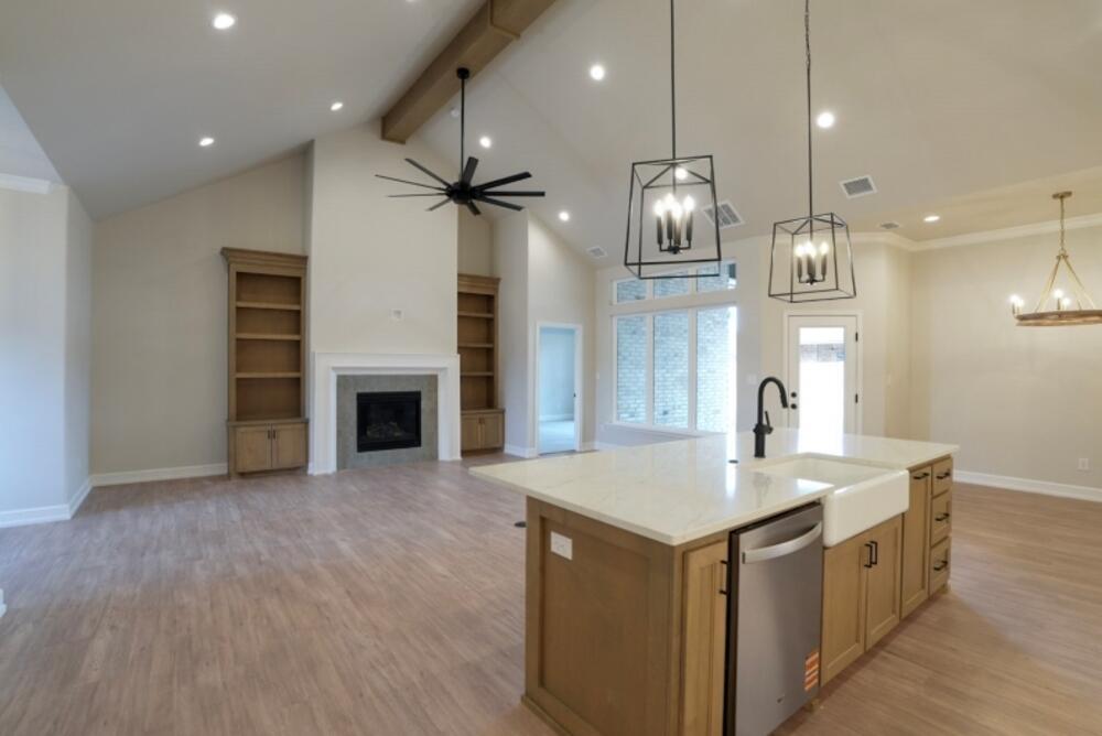 7516 56th Street Lubbock, TX 79407 - Photo 16 of 31 a kitchen with a sink chandelier and fireplace