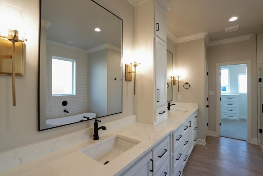 7516 56th Street Lubbock, TX 79407 - Photo 18 of 31 a bathroom with double vanity sinks and a large mirror
