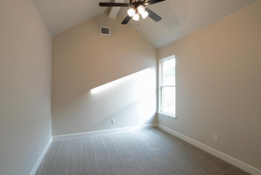 7516 56th Street Lubbock, TX 79407 - Photo 27 of 31 an empty room with windows and chandelier fan