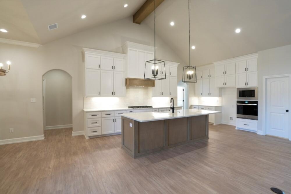 7516 56th Street Lubbock, TX 79407 - Photo 3 of 31 a large kitchen with stainless steel appliances kitchen island granite countertop a large counter top and stove top oven