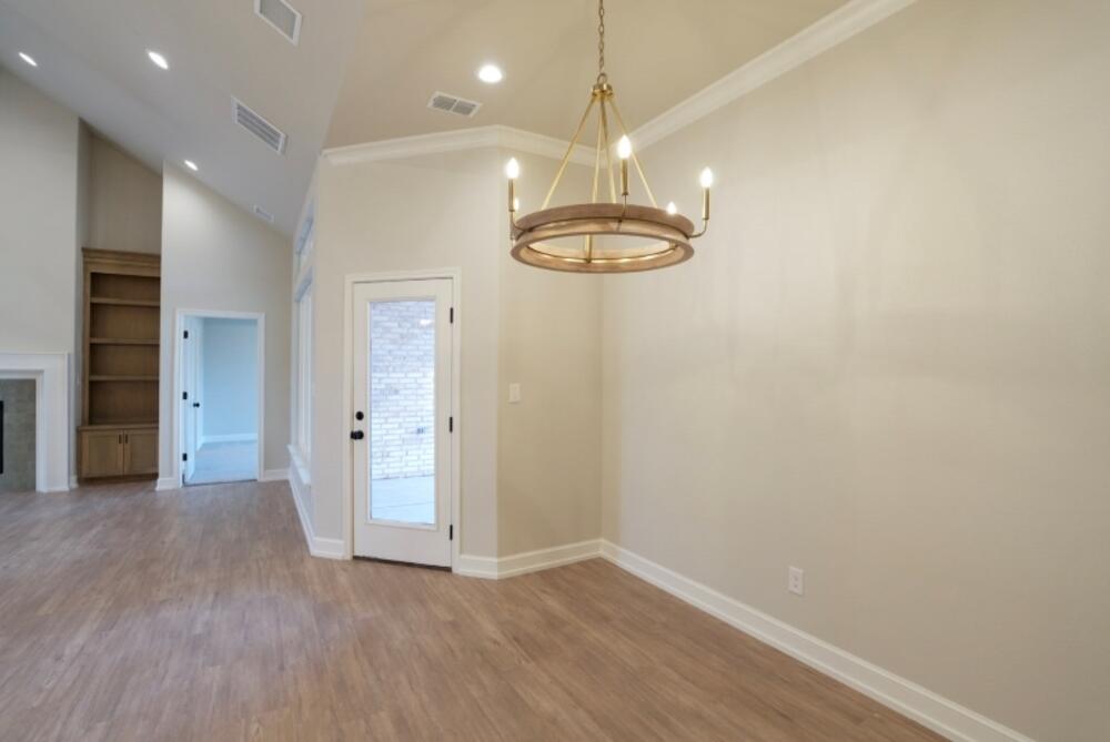 7516 56th Street Lubbock, TX 79407 - Photo 7 of 31 an empty room with wooden floor and chandelier