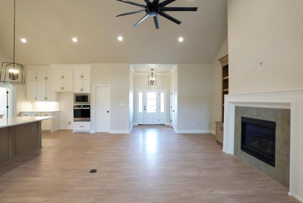 7516 56th Street Lubbock, TX 79407 - Photo 10 of 31 an empty room with kitchen and fireplace