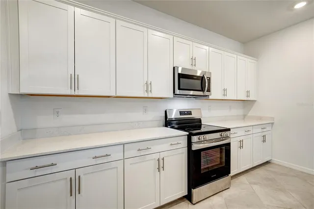 a kitchen with stainless steel appliances granite countertop white cabinets a sink and dishwasher