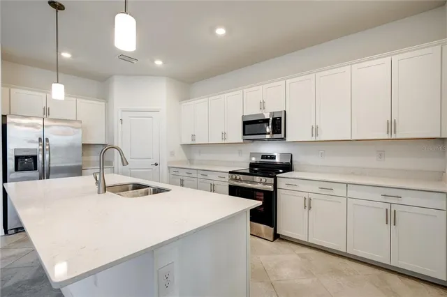a kitchen with kitchen island a sink appliances and cabinets