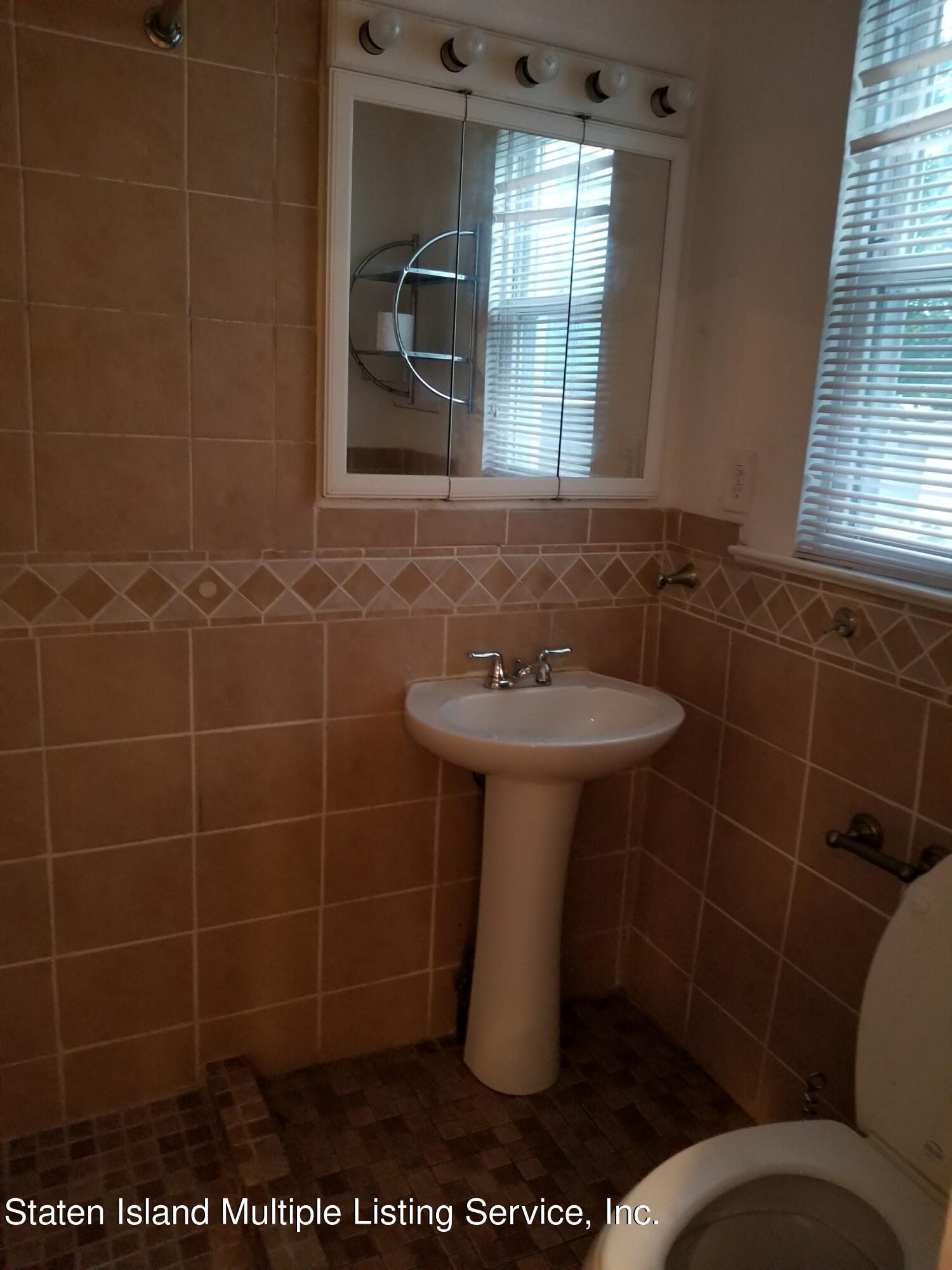 67 New Street Staten Island, NY 10302 - Photo 11 of 13 a bathroom with a sink toilet and window