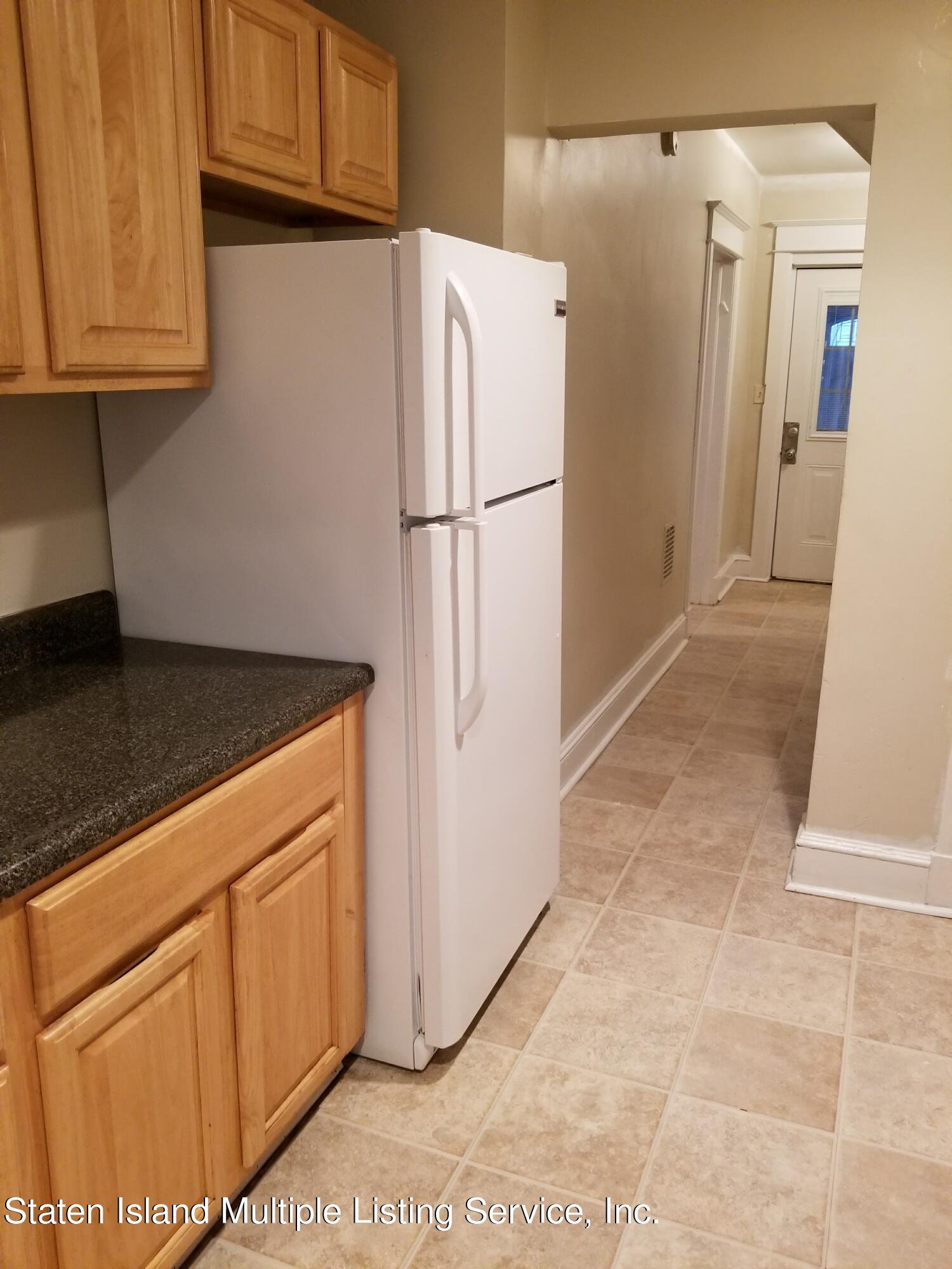 67 New Street Staten Island, NY 10302 - Photo 3 of 13 a white refrigerator freezer and a stove sitting inside of a kitchen