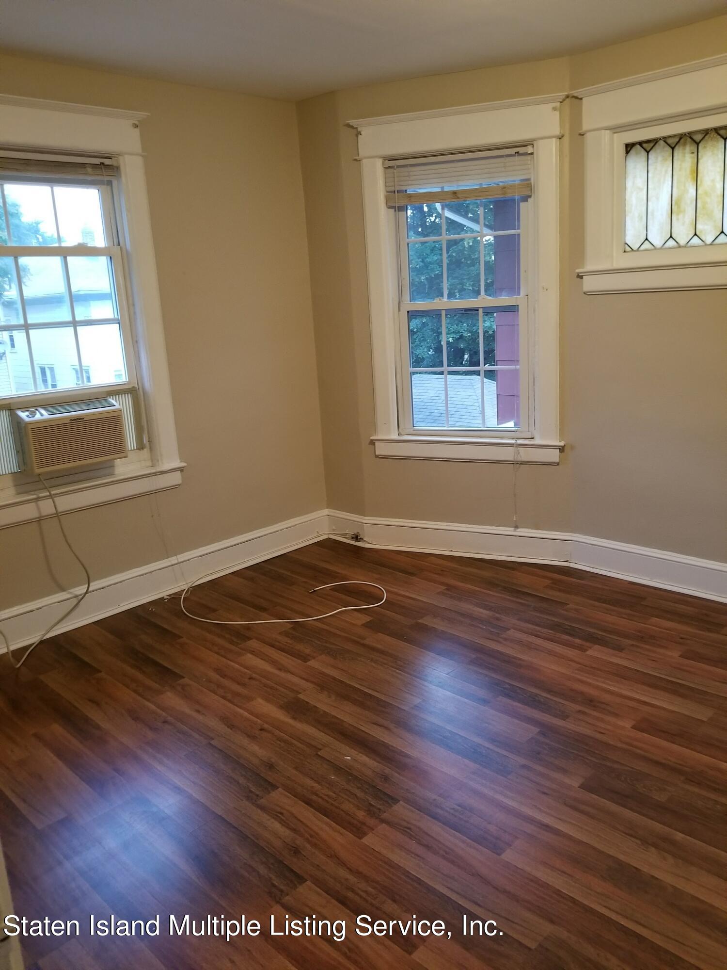 67 New Street Staten Island, NY 10302 - Photo 5 of 13 a view of an empty room with wooden floor and a window