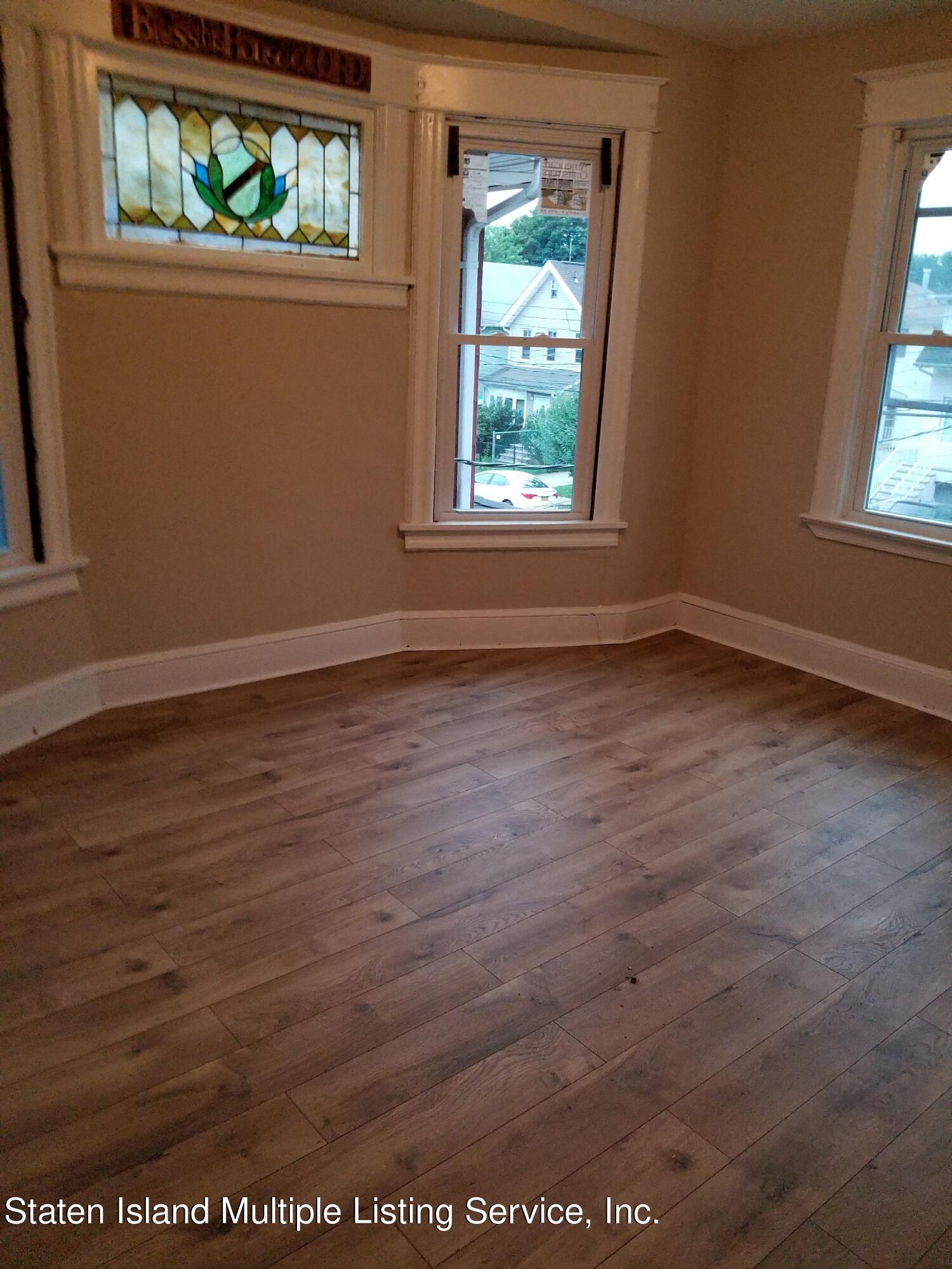 67 New Street Staten Island, NY 10302 - Photo 6 of 13 an empty room with wooden floor and windows