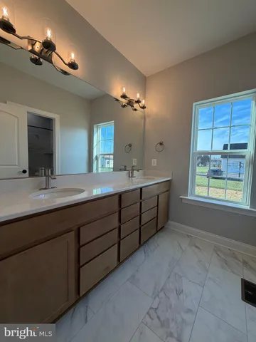 a spacious bathroom with a double vanity sink a mirror and a bathtub