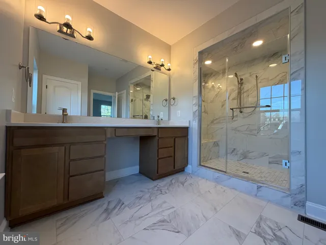 a bathroom with a double vanity sink mirror and shower