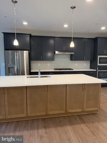 a kitchen with kitchen island a sink and a stove top oven