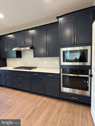 a kitchen with stainless steel appliances granite countertop a stove a microwave and cabinets