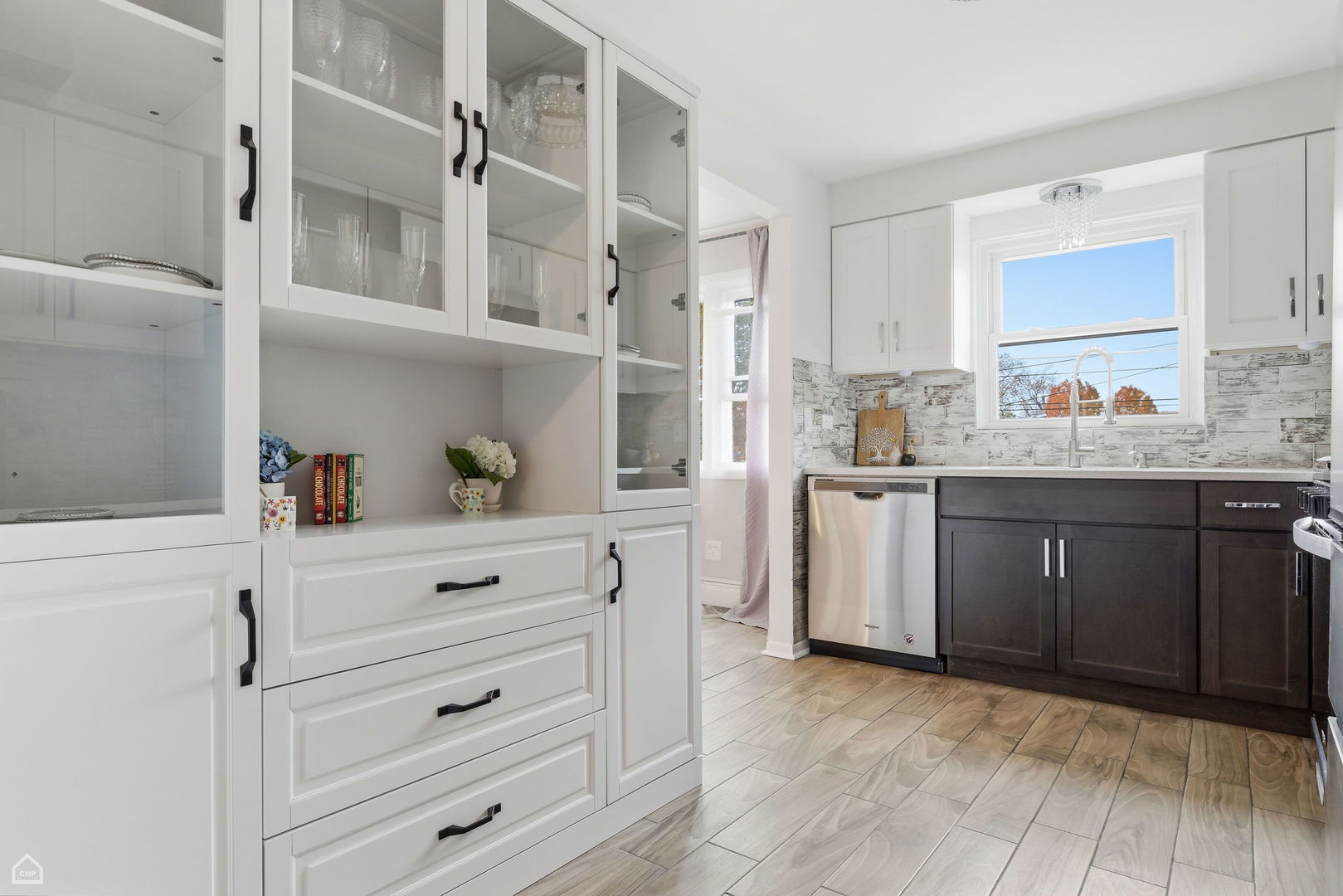 6568 West Roscoe Street, Unit 2N Chicago, IL 60634 - Photo 15 of 31 a kitchen with a sink dishwasher a stove and white cabinets