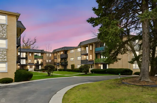 a view of a big house with a big yard and large trees