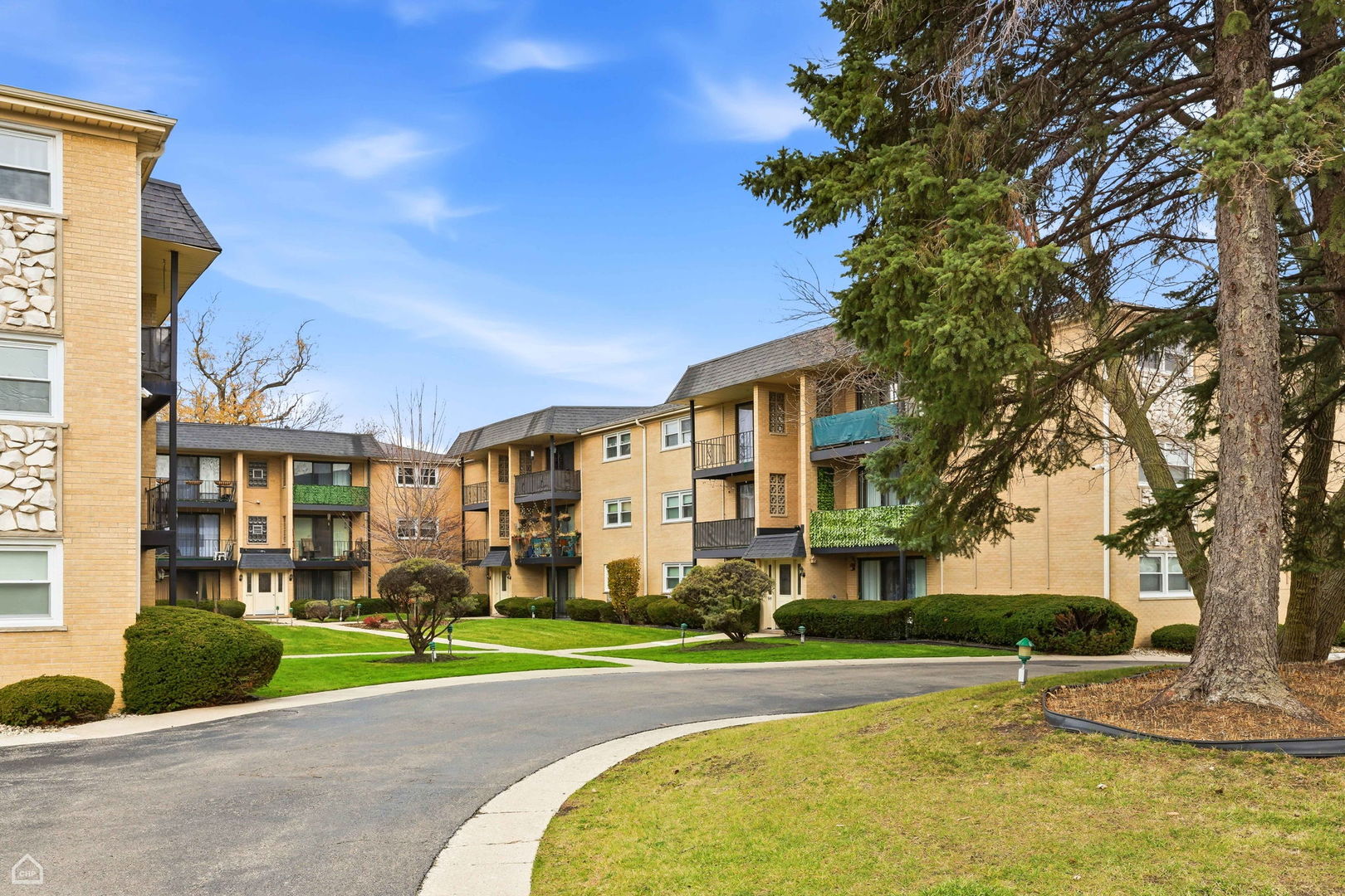 6568 West Roscoe Street, Unit 2N Chicago, IL 60634 - Photo 3 of 31 a view of a big house with a big yard and large trees