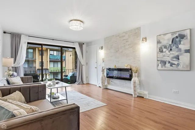 a living room with furniture large window and wooden floor