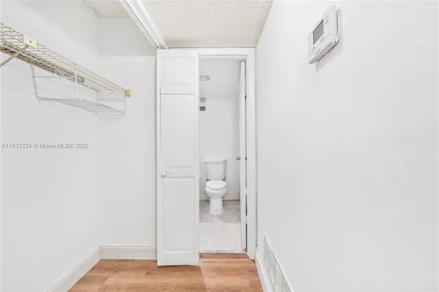 an empty room with closet and windows