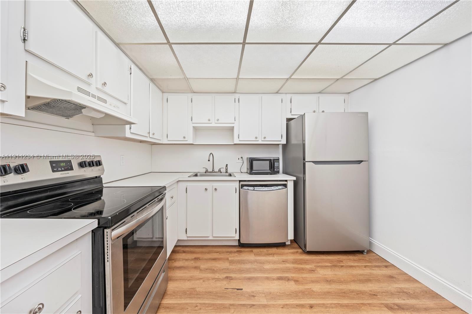 1300 Northeast Miami Gardens Drive, Unit 512E Miami, FL 33179 - Photo 6 of 22 a kitchen with a white cabinets and white appliances