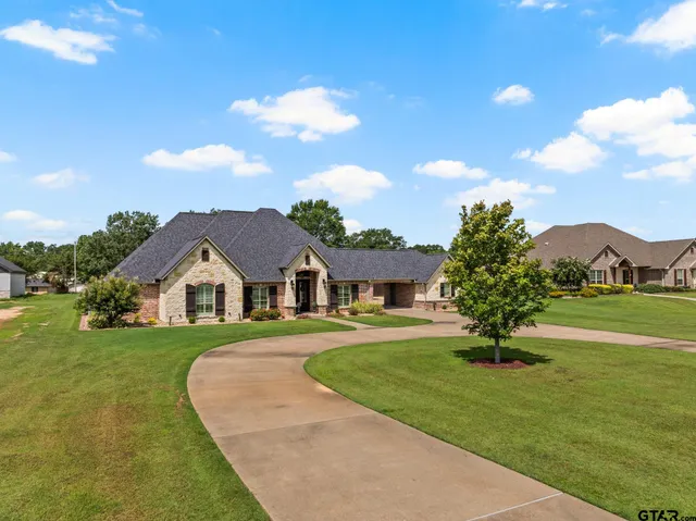 a front view of a house with a garden and yard