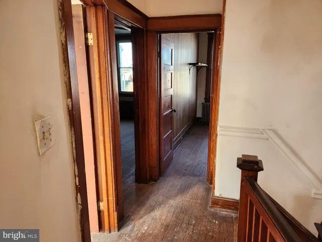 a view of a hallway with closet and wooden floor