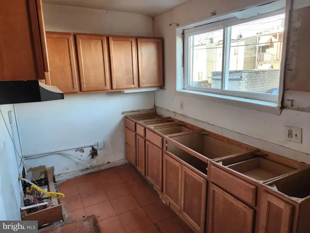 a kitchen that has a sink cabinets and window