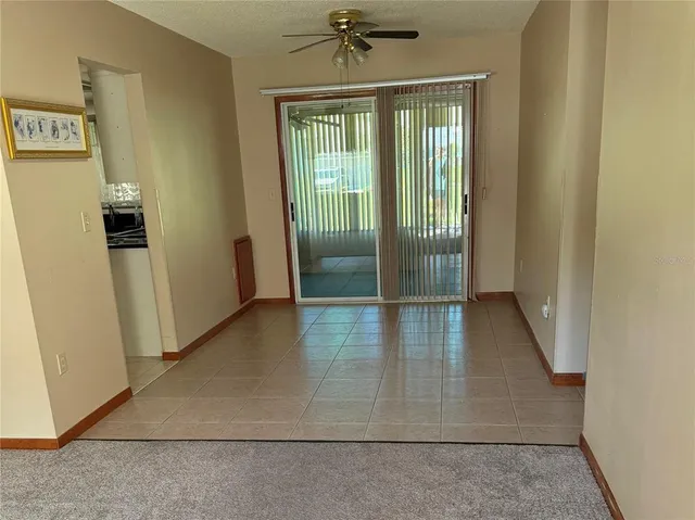 an empty room with wooden floor and a ceiling fan