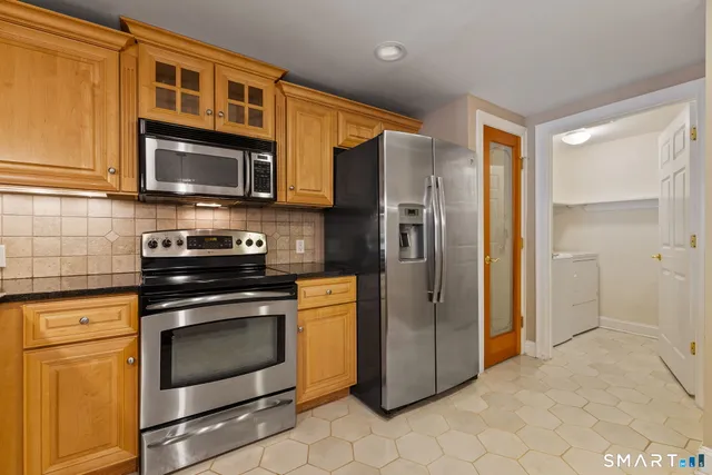 a kitchen with stainless steel appliances granite countertop a refrigerator stove and microwave