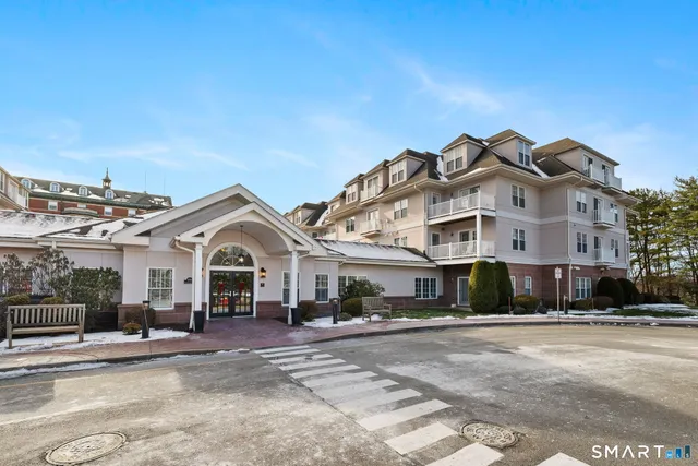a view of a white house with a large windows next to a road