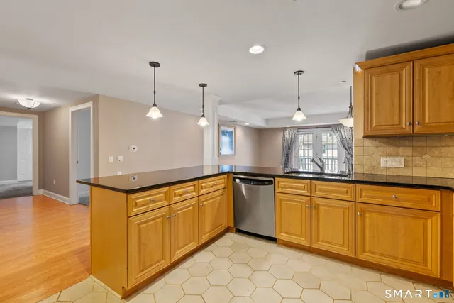 a kitchen with stainless steel appliances granite countertop a sink a stove and a wooden floors