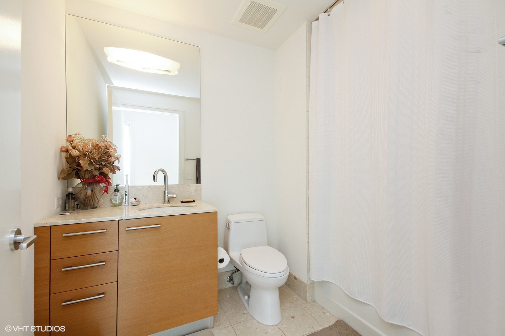 340 East Randolph Street, Unit 1803 Chicago, IL 60601 - Photo 12 of 19 a bathroom with a toilet a sink and mirror