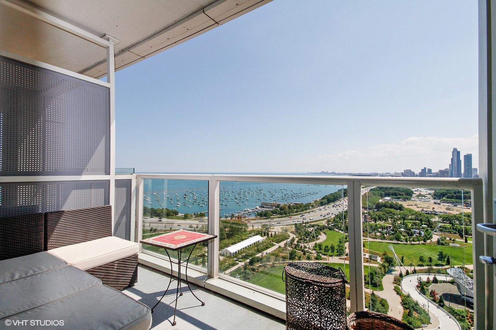 340 East Randolph Street, Unit 1803 Chicago, IL 60601 - Photo 14 of 19 a view of a balcony with chairs and wooden floor